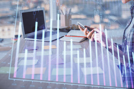 Double exposure of woman hands working on computer and forex graph hologram drawing. Financial...