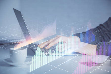 Double exposure of businesswoman hands typing on computer and forex graph hologram drawing....
