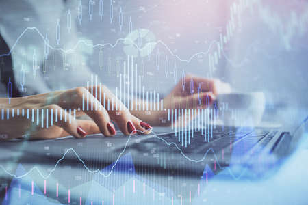 Multi exposure of woman hands typing on computer and financial graph hologram drawing. Stock market...