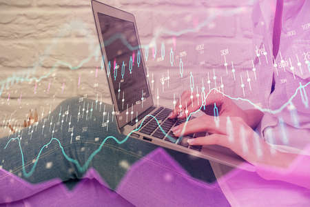Multi exposure of woman hands typing on computer and forex chart hologram drawing. Stock market...