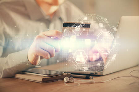 Double exposure of man hands holding a credit card and social network theme drawing. Digital finance...