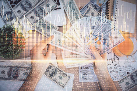 Multi exposure of financial graph drawing hologram and USA dollars bills and man hands. Analysis concept.の写真素材