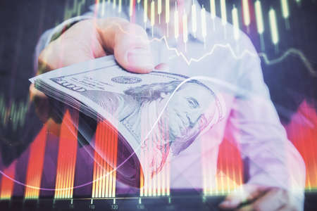 Multi exposure of financial graph drawing hologram and USA dollars bills and man hands. Analysis...