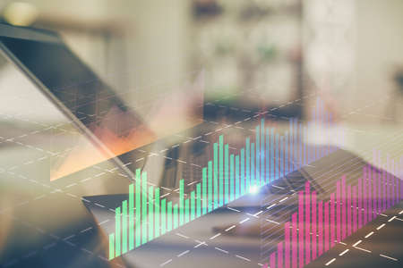 Forex graph hologram on table with computer background. Double exposure. Concept of financial...