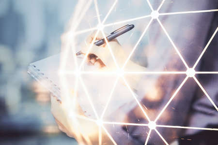 Social network theme hologram over hands taking notes background. Concept of global international people connect. Double exposureの写真素材