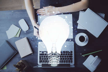 Drawing bulb over womans hands taking notes background. Concept of idea. Double exposureの写真素材