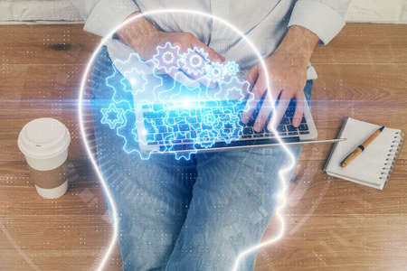 Businessman with computer background with brain theme hologram. Concept of brainstorm. Multi...