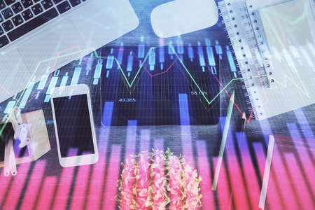 Double exposure of forex chart hologram over desktop with phone. Top view. Mobile trade platform...