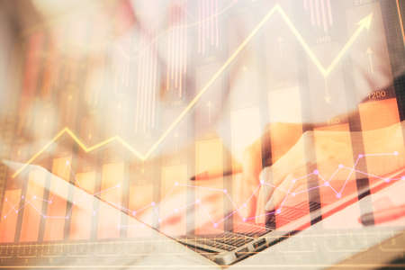 Double exposure of woman hands typing on computer and forex chart hologram drawing. Stock market...