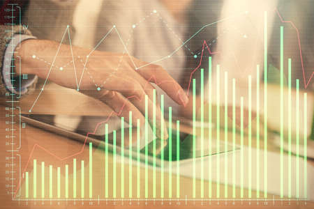 Double exposure of forex graph drawing and man and woman working together holding and using a mobile...