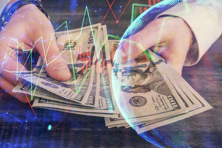 Multi exposure of financial graph drawing hologram and USA dollars bills and man hands. Analysis...