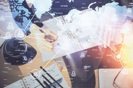 Social network theme hologram over hands taking notes background. Concept of global international people connect. Double exposureの写真素材