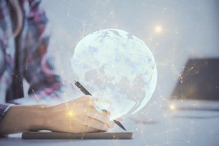 Social network theme hologram over hands taking notes background. Concept of global international people connect. Double exposureの写真素材