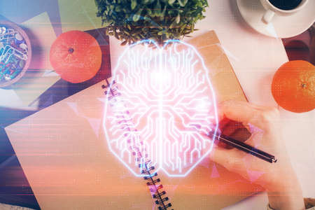 Double exposure of writing hand on background with brain hologram. Concept of learning.の写真素材