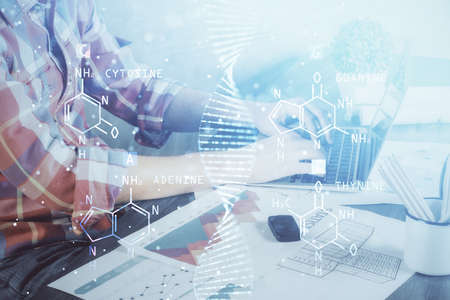 DNA hologram with businessman working on computer on background. Concept of bioengineering. Double...
