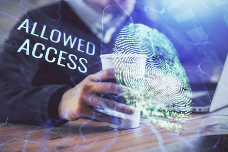 Fingerprint hologram with businessman working on computer on background. Security concept. Double...