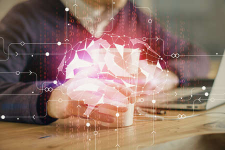 Businessman with computer background with brain theme hologram. Concept of brainstorm. Multi...