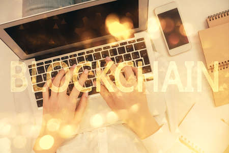Double exposure of woman hands working on computer and blockchain theme hologram drawing. Top View....