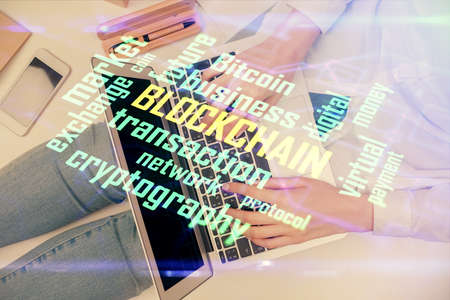 Double exposure of woman hands working on computer and blockchain theme hologram drawing. Top View. bitcoin cryptocurrency concept.の写真素材