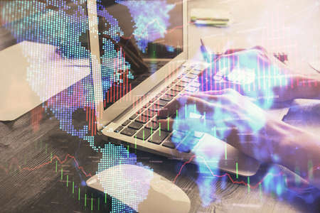 Double exposure of woman hands typing on computer and forex chart hologram drawing. Stock market...