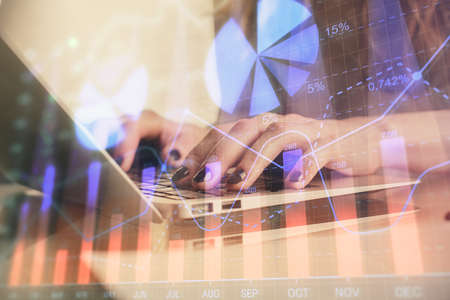 Double exposure of woman hands typing on computer and forex chart hologram drawing. Stock market...