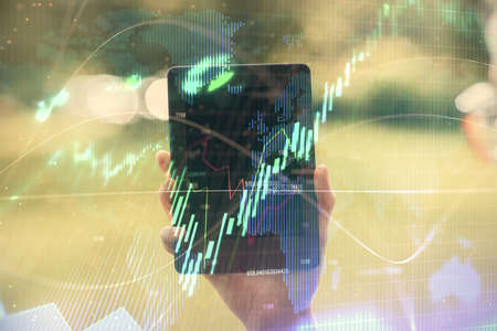 Double exposure of forex chart sketch hologram and woman holding and using a mobile device....