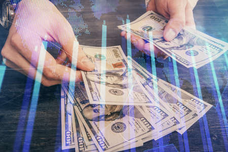 Multi exposure of financial graph drawing hologram and USA dollars bills and man hands. Analysis concept.の写真素材