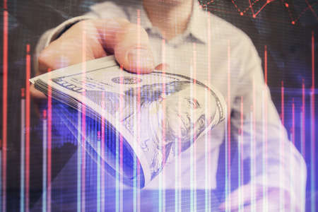 Multi exposure of financial graph drawing hologram and USA dollars bills and man hands. Analysis...