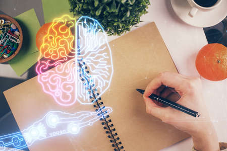 Double exposure of writing hand on background with brain hologram. Concept of learning.
