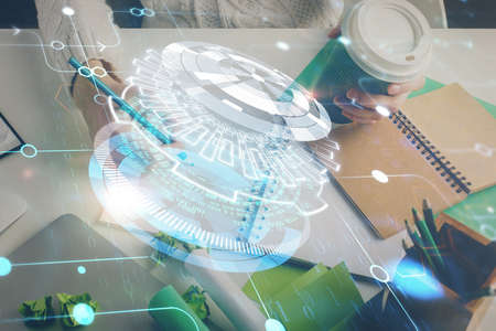 Double exposure of hands making notes background with technology and digital coding huds. Data...