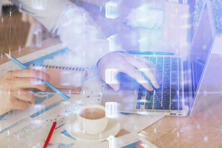 Multi exposure of data internet theme hologram with man working on computer on background. Concept...