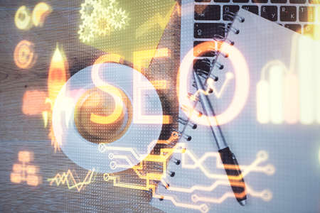 Double exposure of SEO drawing over study table background with computer. Concept of search. Top...