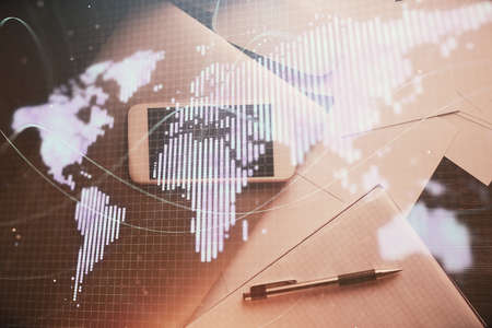 Double exposure of business theme hologram over desktop with phone. Top view. Mobile international...