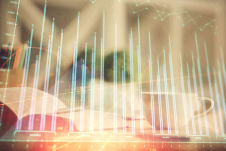 Multi exposure of forex graph drawing and desktop with coffee and items on table background. Concept of financial market tradingの写真素材