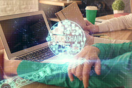 Double exposure of man and woman working together and crypto finance theme hologram. Blockchain...