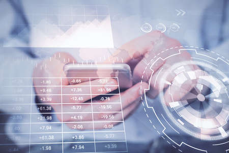 Double exposure of mans hands holding and using a digital device and forex graph drawing. Financial...