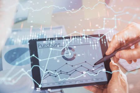 Double exposure of mans hands holding and using a phone and financial chart drawing. Market analysis concept.の写真素材