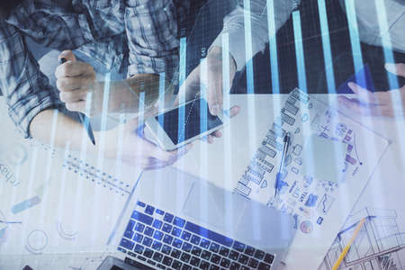 Double exposure of forex graph drawing and man and woman working together holding and using a mobile...