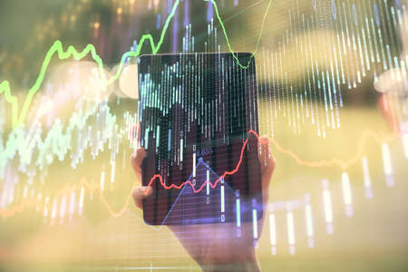 Double exposure of forex chart sketch hologram and woman holding and using a mobile device....