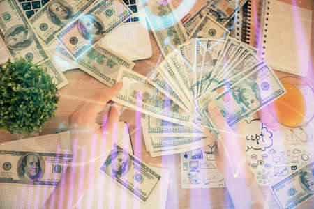 Multi exposure of financial graph drawing hologram and USA dollars bills and man hands. Analysis concept.の写真素材