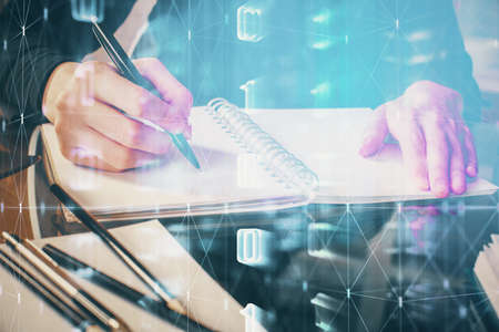 Double exposure of writing hands on background with data solution hologram on front. Technology concept. Close upの写真素材