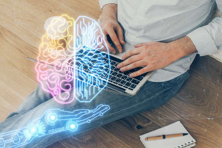 Businessman with computer background with brain theme hologram. Concept of brainstorm. Multi...