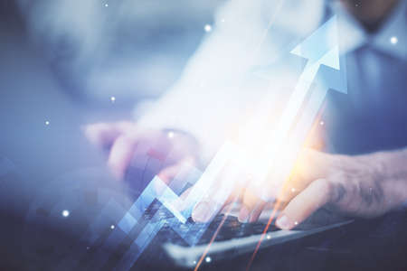 Growing arrows with businessman working on computer on background. Success concept. Double exposure.の写真素材