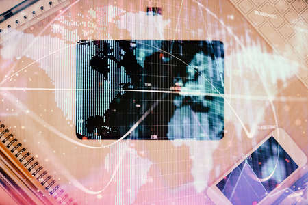 Double exposure of business theme hologram over desktop with phone. Top view. Mobile international trade connection concept.の写真素材