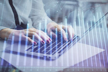 Multi exposure of woman hands typing on computer and financial graph hologram drawing. Stock market analysis concept.の写真素材