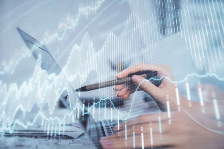 Multi exposure of woman hands typing on computer and financial graph hologram drawing. Stock market...