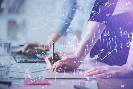 Multi exposure of woman hands typing on computer and financial chart hologram drawing. Stock market...