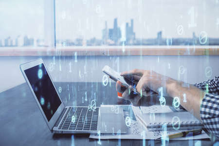 Double exposure of mans hand holding and using a digital device and data theme hologram drawing. Technology concept.の写真素材