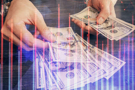 Multi exposure of financial graph drawing hologram and USA dollars bills and man hands. Analysis...