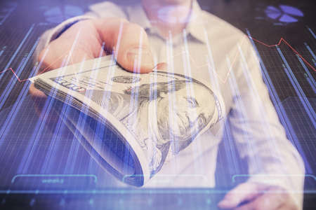 Multi exposure of financial graph drawing hologram and USA dollars bills and man hands. Analysis...